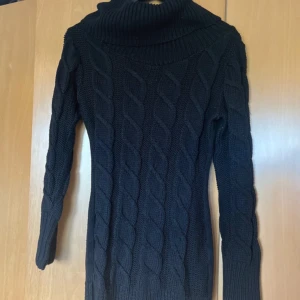 Svart stickad polotröja med kabelmönster xs/s - Mysig svart stickad polotröja med grovt kabelstickat mönster. Tröjan har hög polokrage och långa ärmar, perfekt för kyliga dagar. Snygg och enkel att matcha med jeans eller kjol.