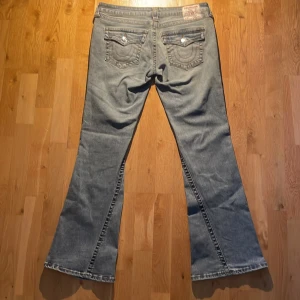 Low rise flared True Religion jeans - Ljus blå flared True Religion jeans med low rise. Midjemått rakt över 42cm och innerbenslängd 80cm. Skriv gärna för mer bilder eller info om byxorna💕