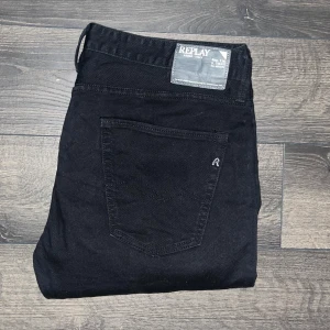 Replay Jennon jeans - Säljer ett par svarta Replay Jennon jeans med klassisk femficksdesign och diskret logga på bakfickan. Jeansen har smal passform och raka ben, tillverkade i mjukt jeanstyg som sitter snyggt. Perfekta för dig som gillar stilrena och enkla svarta jeans. Storlekslappen saknas men jag bedömer storleken till W36, L36, utgå från måtten för att vara säker. Midja 48cm, längd 121cm. JAG SKICKAR INGA FLER BILDER NÄR JAG BÄR JEANSEN :) s2