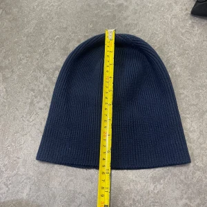 Mörkblå ribbstickad mössa Hampton Republic - Snygg mörkblå ribbstickad mössa från Hampton Republic. Klassisk form med enkel design, perfekt för kalla dagar. Tillverkad i mjukt stickat material som sitter skönt på huvudet. Passar dig som gillar stilren och tidlös look.