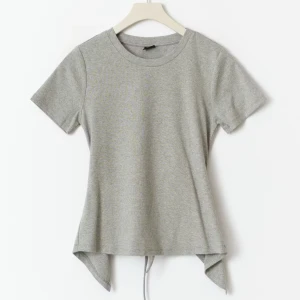 Grå topp med knyt i ryggen - Oanvänd och i nyskick, kommer tyvärr inte till användning. 