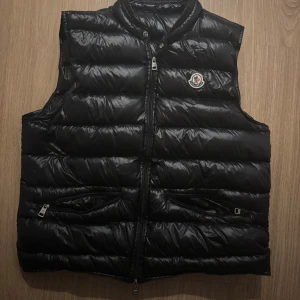 Svart dunväst från Moncler - Svart Moncler gui dunväst storlek 3 passar m. Vet ej om den är äkta, därav priset men nfc chip och qr kod osv funkar. Tveka inte att höra av er vid frågor!