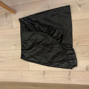 Svart skinnkjol med volang - Snygg svart skinnkjol med volang💓