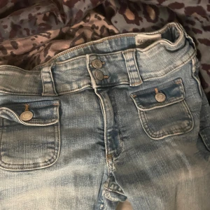 Ursnygga ljusblå jeans!  - Säljer ett par ljusblå jeans med bootcut-modell och snygga fickor framtill med lock och knappar. Jeansen har dubbla knappar i midjan och är lågmidjade. Dm om ni vill ha bild på! De är från HM och är i mycket bra skick! 