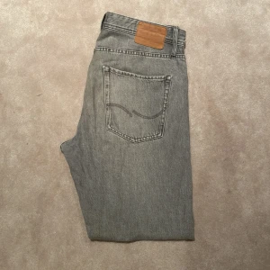 Grå jeans - Gråa jeans ifrån Jack and Jones i färgen grå, storleken är 32/34. Modellen är chris