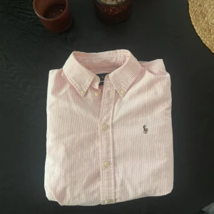Rosa randig skjorta från Ralph Lauren - Säljer en sjukt fet raffe skjorta, skjortan är i jätte bra skick och är i storlek m. Ny pris på dessa är cirka 1699 och mitt är 649 men kan såklart diskuteras!!