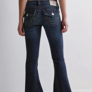 Mörkblå bootcut jeans True Religion - Säljer mina Becca Mid Rise True Religion-jeans, storlek 26. Har använts och sytts upp lite, så de passar perfekt för dig som är kortare. OBS:Bilderna är lånade, men skriv gärna om ni vill att jag skickar egna bilder!