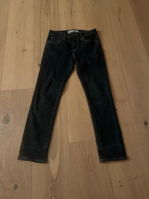 Levi's 520 mörkblå jeans - Säljer ett par mörkblå Levi's 520 Extreme Taper Fit jeans med klassiska fem fickor och kontrastsömmar. Jeansen har en smal passform som smalnar av nedtill och är tillverkade i slitstarkt denimtyg. Perfekta för dig som gillar en modern och clean look.