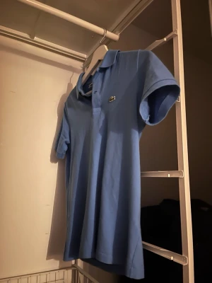 Blå pikétröja från Lacoste - Knappt använd, skick som ny!! köpt ny för 1350. Tveka inte vid att skriva om du har funderingar kring passform eller pris etc🏆 