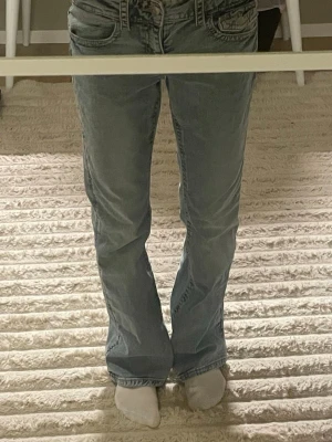 Ljusblå bootcut jeans med fickdetaljer - Säljer ett par ljusblå jeans med bootcut-modell och snygga fickdetaljer både fram och bak. Jeansen har låg midja och är tillverkade i klassiskt denimtyg. Perfekta för dig som gillar en avslappnad och trendig look.💘💘
