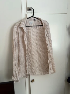 Randig linneskjorta från No 17 - Säljer en beige och vit randig skjorta från No 17 i luftig linneblandning. Skjortan har klassisk krage, knappar framtill och långa ärmar med knapp vid manschetten. Perfekt för en chill och stilren look.