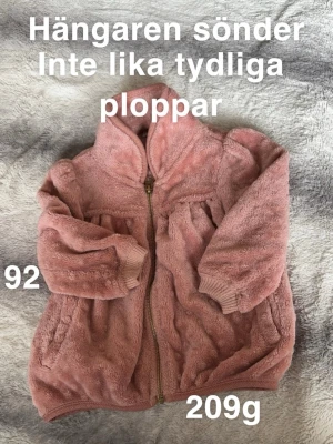 Rosa plupptröja med dragkedja - Mysig rosa kofta i fluffigt med dragkedja framtill. Långa ärmar och ribbade muddar vid handlederna. Perfekt för kyliga dagar och supermjuk att ha på sig.🌸 ”Hängaren” sönder. Inte lika tydliga pluppar