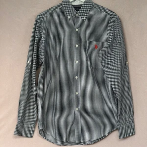 Svartvit rutig skjorta från U.S. Polo Assn. - *Mycket fin och sparsamt använd skjorta i S & Classic fit (relaxed variant).                                                                                                      *Märkt S (amerikanskt), ta gärna en titt på måtten.																																																																																																																															*Ca-mått i cm: Axelbredd: 44, Bröst: 55, Längd: 81 ( se sista bilden).