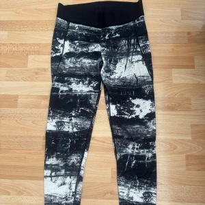 Svarta och vita leggings från H&M Sport XS - Snygga leggings från H&M Sport i storlek XS med svart och vitt abstrakt mönster. Hög midja och stretchigt material i 86% polyester och 14% elastan. Perfekta för träning eller chill dagar.