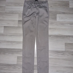 Beige byxor från Vero Moda S/M - Säljer ett par stilrena beige byxor från Vero Moda i storlek S/M. Byxorna har resår i midjan för extra komfort och raka ben. De är tillverkade i ett mjukt bomullsmaterial och passar perfekt för en avslappnad look.