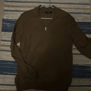 Beige tröja med half zip från Only & Sons - Säljer en stilren beige tröja från Only & Sons med half zip-dragkedja i halsen. Tröjan har lång ärm och ribbade detaljer vid kragen. Perfekt för dig som gillar en clean och enkel look.