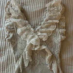 Beige topp med volanger från Zara - Supersöt beige topp från Zara med spetsdetaljer och volanger längs v-ringningen. Väldigt bekväm och super fin💞