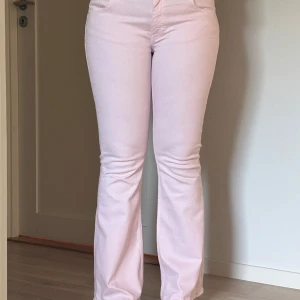 Ljusrosa bootcut jeans från Lager 157 - Snygga ljusrosa jeans från Lager 157 med bootcut passform och låg midja. Jeansen har klassiska fyra fickor, dragkedja och knapp framtill. Materialet är mjukt och stretchigt, vilket gör dem bekväma att bära hela dagen. Perfekt för dig som vill sticka ut med en fräsch färg. Bara använda en gång, säljer för att dom är för korta💕