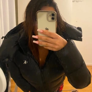 Svart pufferjacka från Calvin Klein - Svart pufferjacka/dunnjacka från Calvin Klein. Varm, mysig men även fin, perfekt för vintern. Dock har liten skada vid kragen därför har den nedsatt pris. Annars i helhet som ny. Använd fåtal gånger. (PRIS KAN DISKUTERAS)