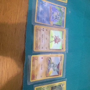 Pokémonkort (samling) - Cool samling av klassiska Pokémonkort, perfekt för dig som älskar nostalgi och samlarvärde! Här hittar du favoriter som Blastoise, Hitmonchan och Machop. Korten är i plastfickor och redo att boosta din samling eller bytas med vänner. Perfekt för unga samlare och Pokémonfans!