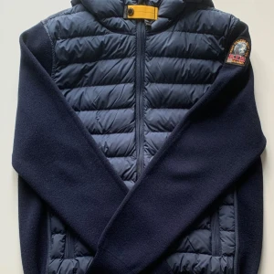 Parajumper Illuga Cardigan - Säljer en snygg mörkblå cardigan från Parajumpers. Perfekt för hösten. Cardiganen är i nyskick, bara använd ett fåtal gånger. Allt medföljer såsom box, brev och tags. Pris kan diskuteras. Kontakta vid intresse.