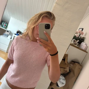 Ljusrosa stickad kortärmad tröja - Superfin ljusrosa stickad tröja med korta ärmar och ribbade kanter. Tröjan har en mjuk och mysig känsla och är perfekt för vår och sommar. Enkel att matcha med både jeans och kjol för en söt look.