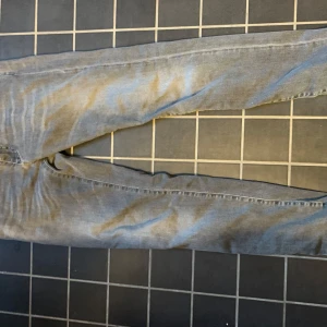 Dolce & Gabbana grå jeans - Snygga grå jeans från Dolce & Gabbana med DG-logga på bakfickan. Jeansen har klassisk femficksdesign och är tillverkade i stretchigt denim för extra komfort. Passformen är rak och färgen är ljusgrå, vilket ger en stilren och modern look.