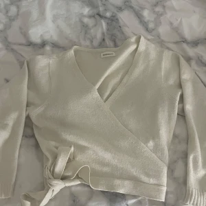 Beige omlottkofta från Even&Odd - Superfin beige omlottkofta från Even&Odd med knyt i midjan och v-ringad hals. Koftan är stickad och har långa ärmar, perfekt för lager-på-lager och en chill look. Storlek M men är en S skulle jag säga.