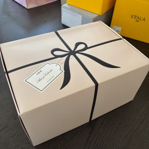 Caias julkalender 2025 - Snygg och stilren svart necessärväska från CAIA i skinnimitation med praktiskt handtag och dragkedja runt om. Insidan har flera fack och elastiska hållare för sminkborstar eller penslar. Perfekt för att organisera smink eller hudvård på resan.