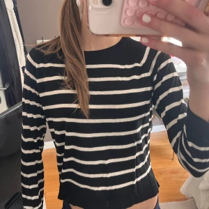 Randig svartvit tröja från Zara - Snygg svart tröja med vita horisontella ränder från Zara. Modellen är rak med rund halsringning och långa ärmar. Perfekt för dig som gillar klassiska mönster och enkel stil. Materialet känns mjukt och lätt på kroppen.