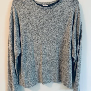 Grå långärmad tröja från Name It - En enkel och mjuk, tunnare stickad grå långärmad tröja från Name It. 