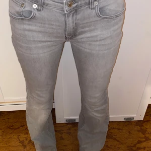 Grå bootcut jeans från 157 - Snygga grå jeans från 157. Jeansen är ”lågmidjade” och är tillverkade i mjukt bomullsmaterial med lite stretch för skön passform. Perfekta för dig som gillar lågmidjade bootcut. 