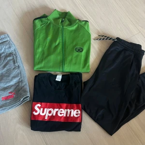 Träningskläder säljes  - T-shirt och träningsjackan i strl S, byxan i strl 160 och shortsen i strl 12-13 år. Svarta mjukisbyxor med elastisk midja och dragsko. Byxorna har en smal passform och är tillverkade i ett mjukt och bekvämt material, perfekta för chill eller träning. Diskret logga på ena benet och fickor i sidorna. 