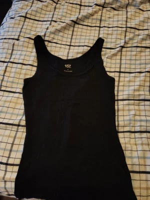Svart linnetopp från 157 - En enkel och stilren svart linnetopp från 157. Toppen är ärmlös med breda axelband. Säljer då den är aldelles för stor och är mer en M än S. Aldrig använd och inga defekter.