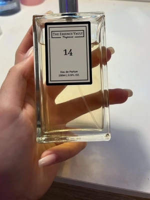The Essence Vault 14 Eau de Parfum - En stilren parfym från The Essence Vault med nummer 14. Flaskan är rektangulär i genomskinligt glas med en enkel svartvit etikett. Innehåller 100 ml Eau de Parfum. Perfekt för dig som gillar minimalistisk design och fräscha dofter. Har bara använts 1 gång! Pris kan diskuteras.