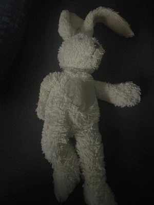 Vit mjuk kaninnalle - Söt vit mjuk kanin i plysch med långa öron och broderad nos. Perfekt som gosedjur eller dekoration. Kaninen har en klassisk form och är tillverkad i mjukt tyg som är skönt att krama.