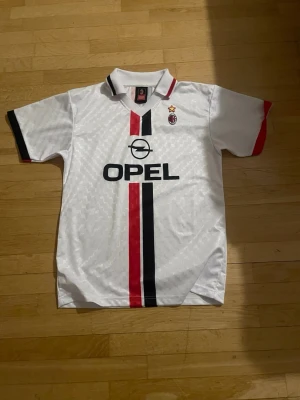 AC Milan retro matchtröja 1995/96 - Vit AC Milan retrotröja från Lotto med klassiska röda och svarta ränder framtill. Köpt på San Siro!