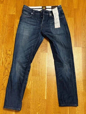 Tramarossa Jeans - Säljer ett par exklusiva ”Leonardo” jeans från Tramarossa, storlek 30, total längd 95 cm. Blå med djup och elegant färg samt genomarbetade detaljer. Handgjorda i Italien av premiummaterial, med samtliga skräddare som deltagit i tillverkningen personligen signerade, ett tydligt kvalitets- och hantverksmärke.