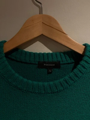 Grön stickad tröja från Matinique - Snygg grön stickad tröja från Matinique med rund halsringning och ribbade muddar. Tröjan har en enkel och stilren design som passar perfekt till jeans eller chinos. Materialet känns mjukt och bekvämt mot huden. Mer som S/M.