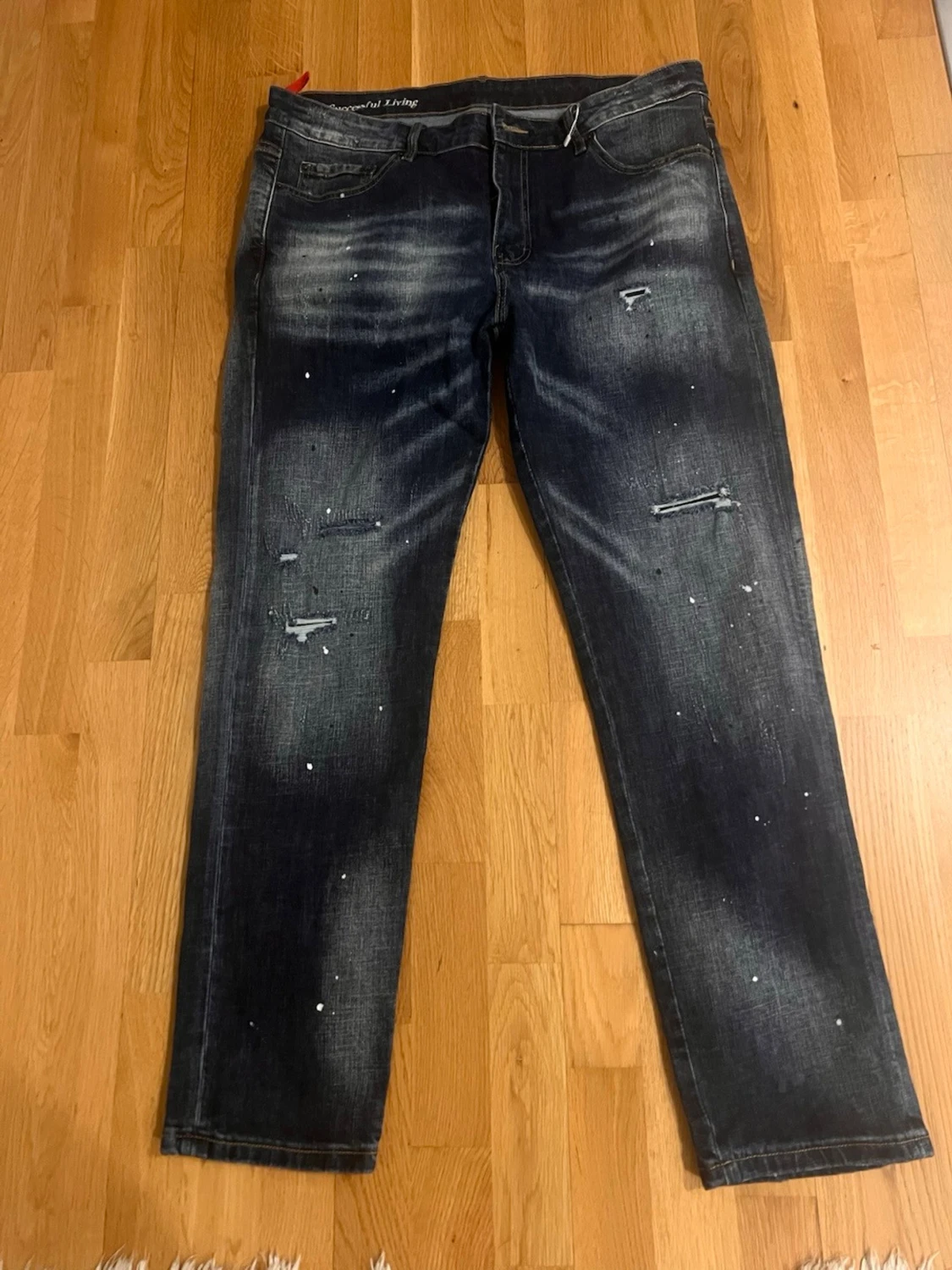Mörkblå distressed jeans med stänk