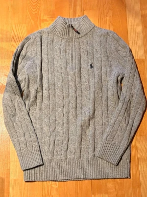 Grå kabelstickad tröja  - Säljer en riktigt snygg kabelstickad grå tröja i nyskick, aldrig använd. Perfekt nu inför våren! Priset kan diskuteras!