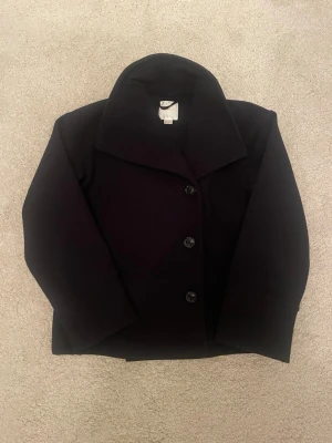 Marinblå ullkappa med bred krage - Stilren marinblå kappa med bred krage och tre knappar framtill. Perfekt för våren 😍❤️