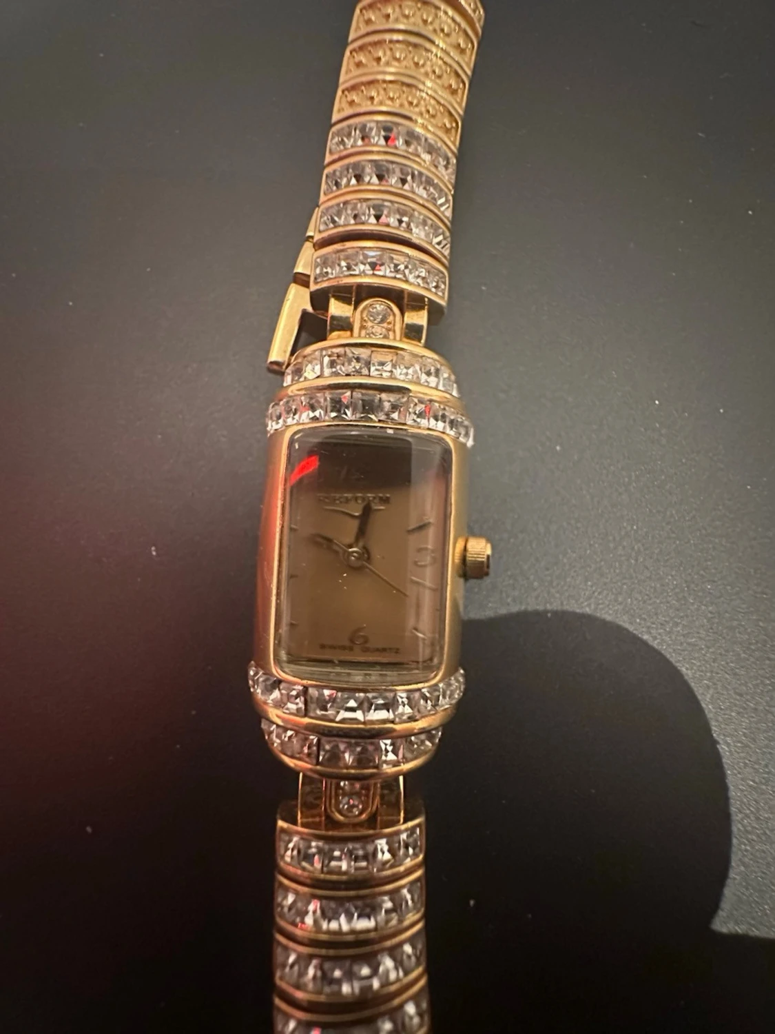 Guldig rektangulär klocka med stenar