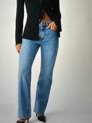 Classic boot Gina tricot  - Säljer ett par klassiska blå jeans med rak passform och hög midja. Jeansen har fem fickor, knappgylf och är tillverkade i ett slitstarkt denimtyg. Perfekta för en avslappnad och trendig look.