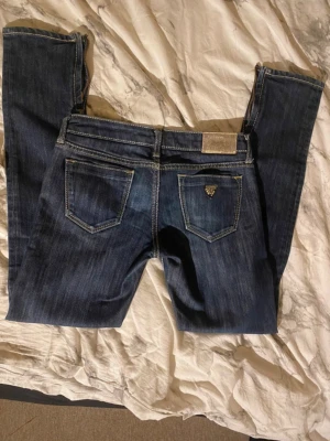 Mörkblå jeans från Guess Premium - Säljer nu mina Guess premium jeans då dom är för små dom har en dragkedja nere vid foten, jag har aldrig använt dom har enbart testat. Köpta secondhand för 429kr. Står ingen storlek men här är alla mått.  Midjemått: 36cm (rakt över) Innerbenslängd: 70cm Ytterben: 87cm Skrev: 16 cm              Skulle säga att dom Passar en S-XS. Skriv gärna om du har frågor och pris går alltid att diskutera!                  SKRIV INNAN DU KÖPER