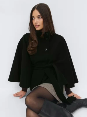 Svart kappa - Stilren svart poncho från Gina med knapp uptill och brett knytband i midjan. Kappan har en lös, svepande passform och hög krage. Perfekt för dig som vill ha en trendig och elegant look.