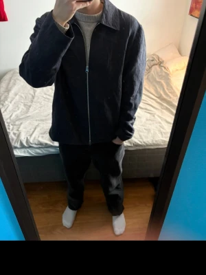 Mörkblå overshirt med dragkedja - Säljer en stilren mörkblå overshirt med dragkedja framtill och klassisk krage. Overshirten har en rak passform och är tillverkad i ett strukturerat tyg som ger en modern look. Perfekt att slänga över en t-shirt eller hoodie för en avslappnad stil.