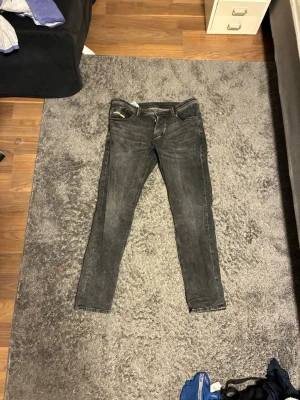 Svarta skinny jeans från disel - Säljer ett par svarta jeans från disel med klassisk femficksdesign och disel-lapp bak i midjan. Jeansen har smal passform och är tillverkade i ett stretchigt denimtyg som sitter snyggt. Perfekta för dig som gillar snygga och stilrena jeans 