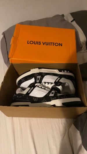 Svartvita sneakers - Sneakers i svart och vitt med klassiskt monogrammönster. Låg modell med snörning, platt sula och rund tå. Snygg kontrast mellan svart och vit, perfekt för dig som gillar exklusiv streetstyle.