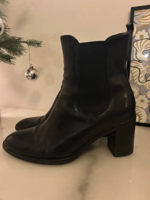 Svarta chelsea boots med klack - Snygga svarta chelsea boots med bred klack och rund tå. Från fantasy köpta för cirka 1100. Meddela för flera frågor,bilder eller diskutera pris💛💛